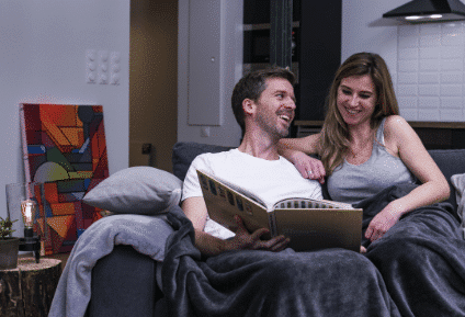 2 personnes sur le canapé avec une couverture pondérée made in france