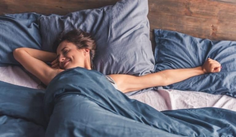 une femme dans son lit avec sa couette pondérée