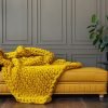 couverture_lestee_tricotee_jaune couverture lestée tricotée laine couleur moutarde sur canapé jaune