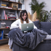 femme__sur_canapé_avec_ordinateur_couverture_lestée-1 femme derrière son ordi sur le canapé avec une couverture lestée